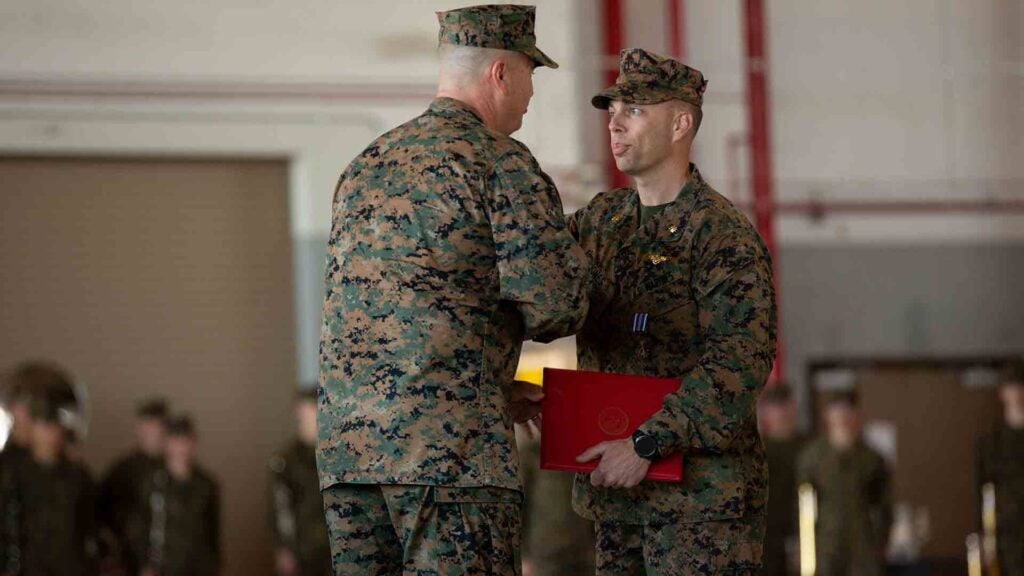 U.S. Marine Corps Maj. Corey Jones, a KC-130J Super Hercules pilot with Fleet Replacement Detachment (right) shakes hand with Maj. Gen. Michael Cederholm, Commanding General of 2nd Marine Aircraft Wing, during an awards ceremony at Marine Corps Air Station Cherry Point, North Carolina, Feb. 28, 2022. Jones, a native of Charlotte, North Carolina, was awarded the Distinguished Flying Cross for conducting an emergency landing after another aircraft collided with his KC-130J Super Hercules. Jones’ piloting skills and timely decisions during the most critical moments of the 12 minutes from mid-air impact to landing are the reasons the entire aircrew were able to walk off the aircraft and are alive today. (U.S. Marine Corps photo by Sgt Servante R. Coba)