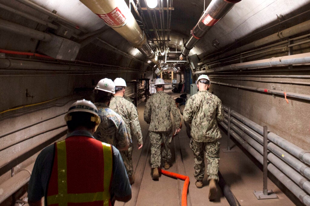 FILE - In this Dec. 23, 2021, photo provided by the U.S. Navy, Rear Adm. John Korka, Commander, Naval Facilities Engineering Systems Command (NAVFAC), and Chief of Civil Engineers, leads Navy and civilian water quality recovery experts through the tunnels of the Red Hill Bulk Fuel Storage Facility, near Pearl Harbor, Hawaii. Native Hawaiians who revere water in all its forms as the embodiment of a Hawaiian god say the Navy's acknowledgement that jet fuel leaked into Pearl Harbor's tap water has deepened the distrust they feel toward the U.S. military. (Mass Communication Specialist 1st Class Luke McCall/U.S. Navy via AP, File)