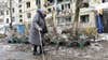 A woman walks by apartment building damaged after shelling the day before in Ukraine's second-biggest city of Kharkiv on March 8, 2022. - The number of people fleeing the war flooding across Ukraine's borders to escape towns devastated by shelling and air strikes passed two million, in Europe's fastest-growing refugee crisis since World War II, according to the United Nations. (Photo by Sergey BOBOK / AFP) (Photo by SERGEY BOBOK/AFP via Getty Images)