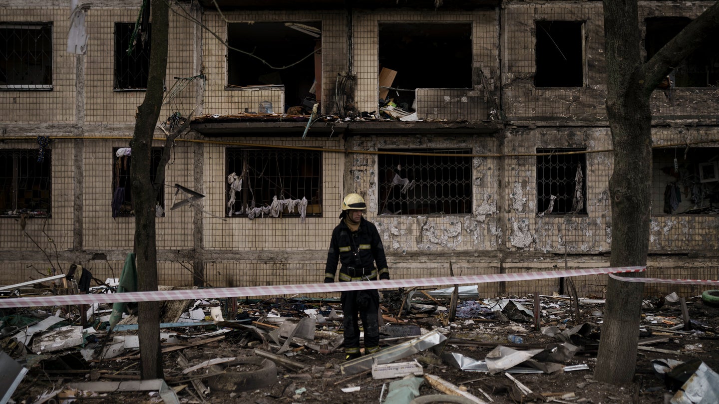 A Ukrainian firefighter walks outside a destroyed building after it was hit by artillery shelling in Kyiv in Kyiv, Ukraine, Monday, March 14, 2022. (AP Photo/Felipe Dana)
