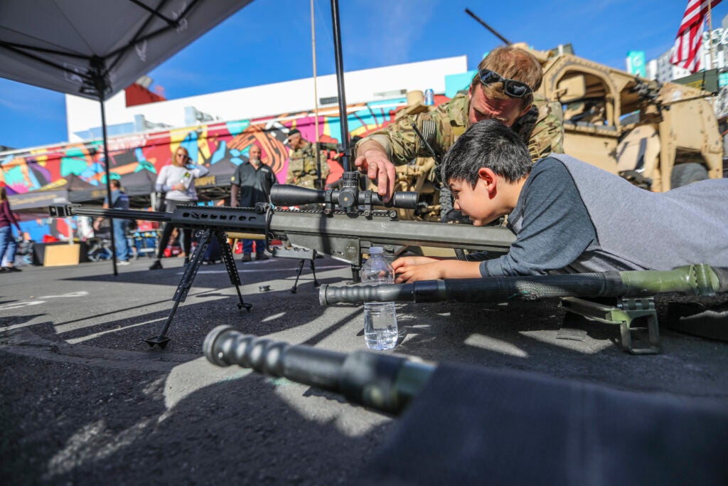 A Green Beret with the 5th Special Forces Group (Airborne), shows a child a Barrett .50 caliber sniper rifle, March 05, 2020, at the Mint 400 Meet and Greet Festival in Las Vegas, Nevada. (U.S. Army photo by Staff Sgt. Justin Moeller, 5th SFG(A) Public Affairs)