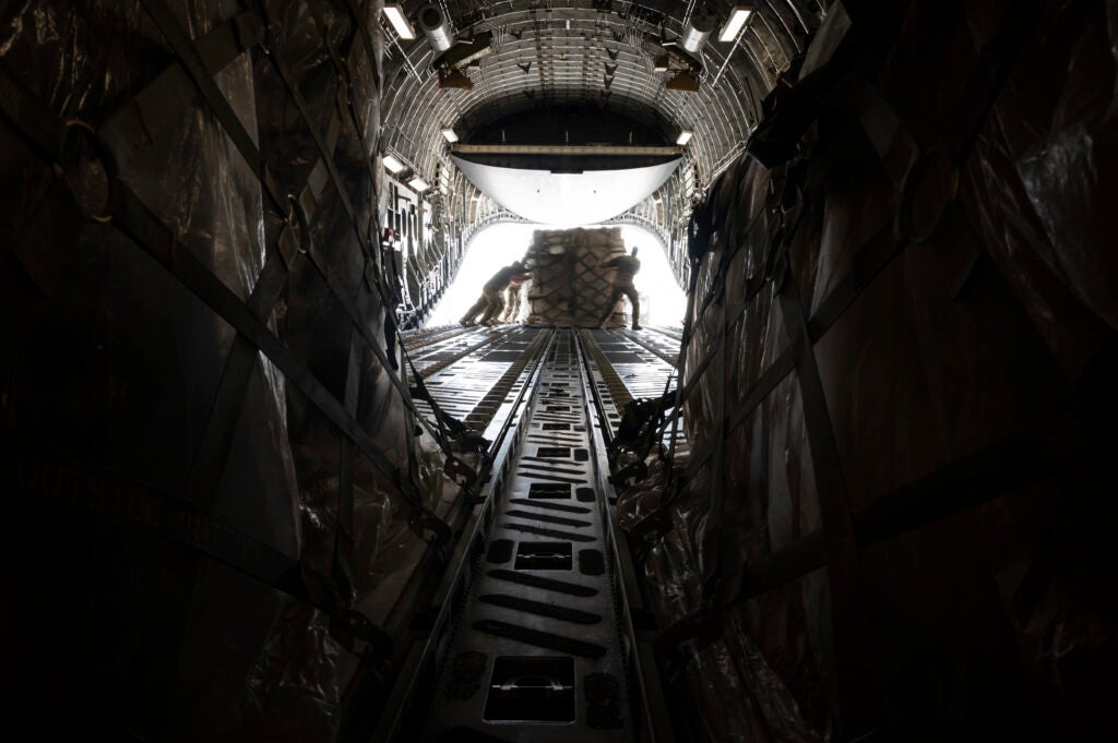 U.S. Airmen assigned to the 386th Expeditionary Logistics Readiness Squadron and 816th Expeditionary Airlift Squadron load cargo onto a U.S. Air Force C-17 Globemaster III at Ali Al Salem Air Base, Kuwait, March 2, 2022. The 816th EAS, deployed with Ninth Air Force (Air Forces Central), is responsible for delivering cargo and personnel to U.S. and partner nation forces' bases, providing airpower to U.S. Central Command area of responsibility. (U.S. Air Force photo by Staff Sgt. Joseph Pick)