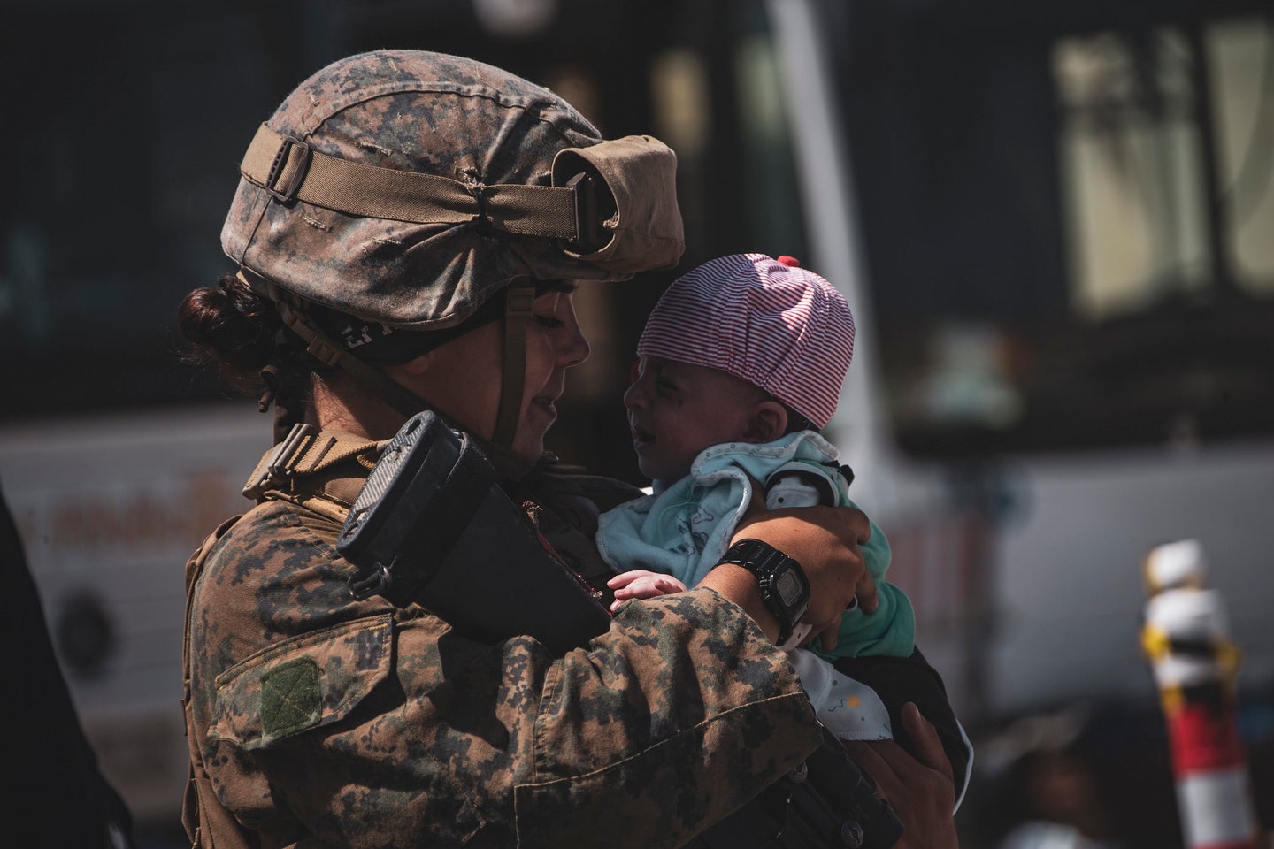 A Marine assigned to the 24th Marine Expeditionary Unit calms down an infant at Hamid Karzai International Airport, Afghanistan, on Aug. 28. (Cpl. Davis Harris/U.S. Marine Corps.)