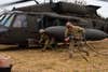 U.S. Soldiers carry refueling equipment from a UH-60 Black Hawk helicopter at a forward refueling point in Zamosc, Poland, March 5, 2022. The focus of the 82nd Airborne Division's mission is to assure our Allies by providing a host of unique capabilities and conducting a wide range of missions that are scalable and tailorable to mission requirements.