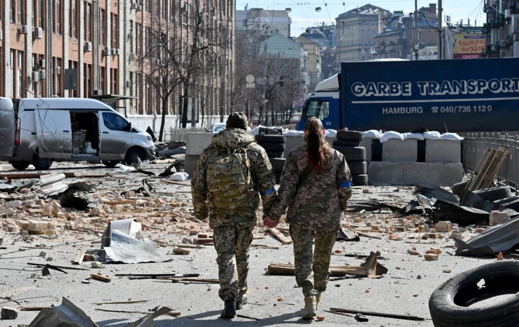 TOPSHOT - A couple of Ukrainian soldiers walks hand in hand amid Russian invasion of Ukraine in Kyiv on March 17, 2022, as Russian troops try to encircle the Ukrainian capital as part of their slow-moving offensive. (Photo by Sergei SUPINSKY / AFP) (Photo by SERGEI SUPINSKY/AFP via Getty Images)