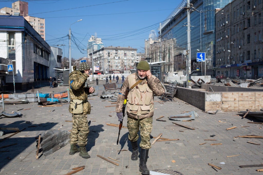 KYIV, UKRAINE - MARCH 15: Ukrainian servicemen are seen by the building which got shelled near Lukyanivska metro station on March 15, 2022 in Kyiv, Ukraine. Russian forces continue to attempt to encircle the Ukrainian capital, although they have faced stiff resistance and logistical challenges since launching a large-scale invasion of Ukraine last month. Russian troops are advancing from the northwest and northeast of the city.  (Photo by Anastasia Vlasova/Getty Images)
