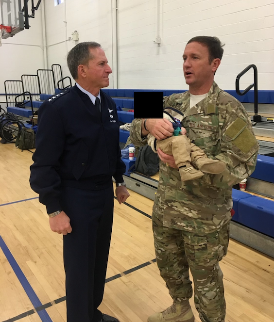  Then-AFW2 director (vs head) Col. Mike Flatten carrying one of his children while speaking with then-Chief of Staff of the Air Force Gen. David Goldfein at a CARE event at Andrews Air Force Base, Md., Nov. 2017 (Courtesy photo)