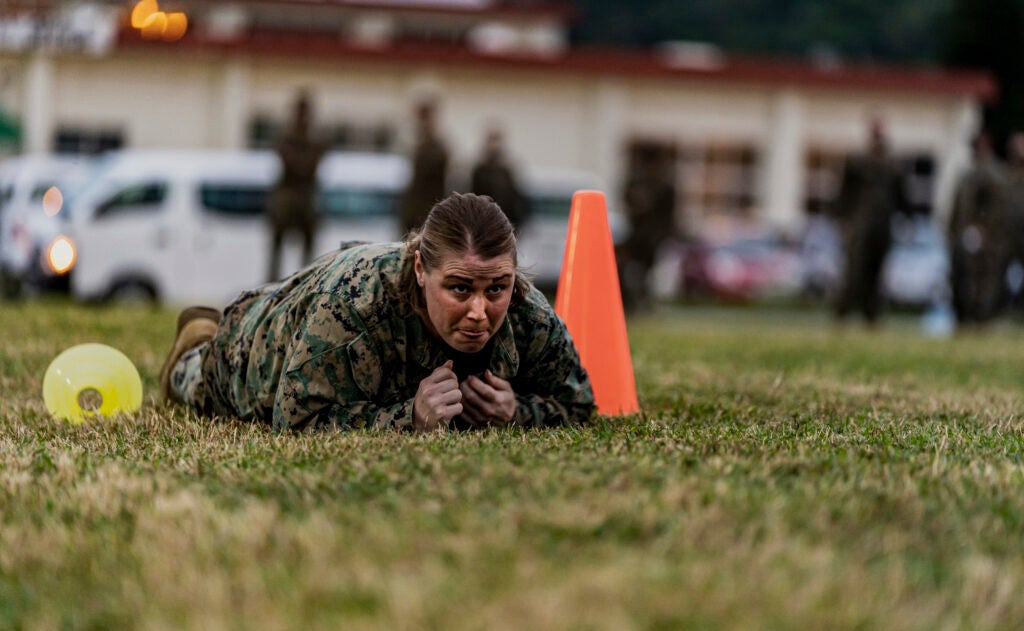 U.S. Marine Corps Gunnery Sgt. Devon M. McNeil, the administrative chief with Headquarters and Support Battalion, executes a low crawl during the combat fitness test on Camp Foster, Okinawa, Japan, Nov. 25, 2020. The CFT is an annual requirement and is designed to assess a Marine's physical capacity in a broad spectrum of combat related tasks. (U.S. Marine Corps photo by Cpl. Brennan J. Beauton)
