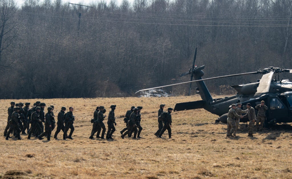 U.S. Paratroopers assigned to the 3rd Brigade Combat Team, 82nd Airborne Division escort members of the Polish military towards a UH-60 Black Hawk helicopter during cold load training in Bircza, Poland, March 15. The 82nd Airborne Division, based out of Fort Bragg, N.C., is training alongside their Polish Allies to increase interoperability and assure our Allies helping to reinforce our Ironclad Alliance. (U.S. Marine Corps photo by Sgt. Robin Lewis)
