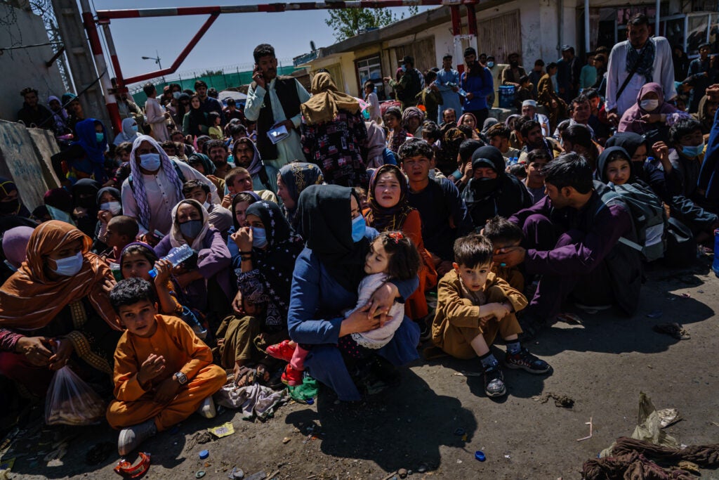 Women and children are made to crouch and wait outside the Taliban controlled check point near the Abbey Gate, before making their way towards the British military controlled entrance of the airport, in Kabul, Afghanistan, Wednesday, Aug. 25, 2021. (MARCUS YAM / LOS ANGELES TIMES)