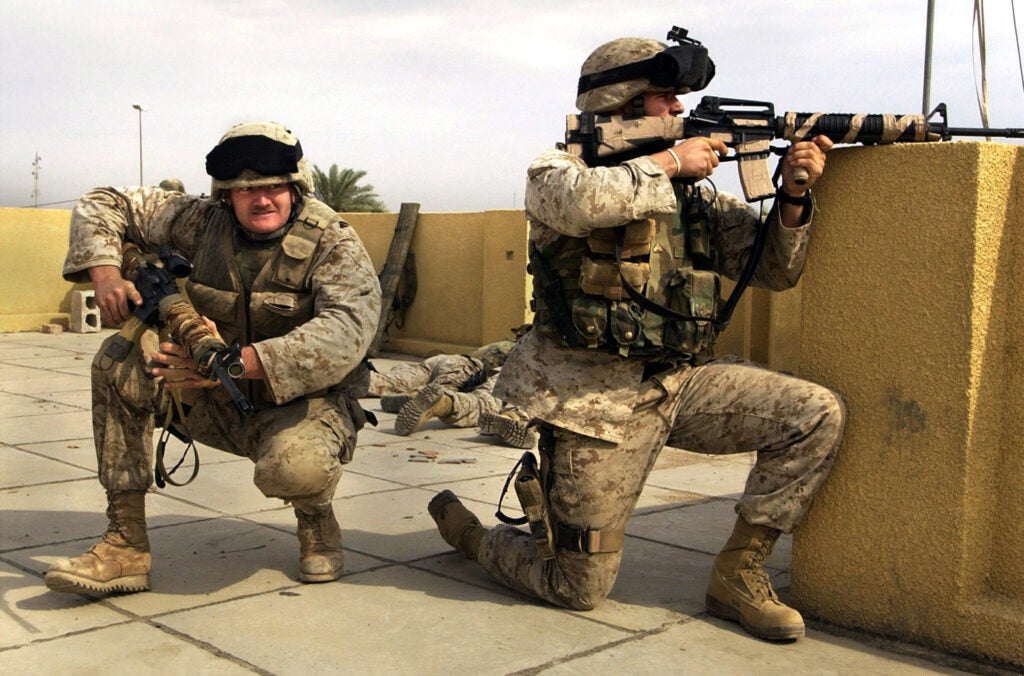 U.S. Marine snipers from the 2nd Battalion, 5th Marine Regiment, take cover during a gun battle with insurgents in Ramadi in Anbar province, Iraq on Oct. 31, 2004. (Jim MacMillan/AP)