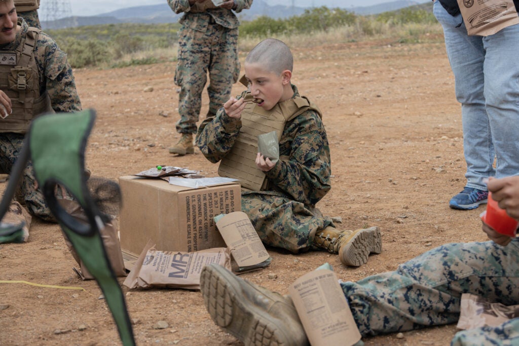 Wyatt, a child with the Make-a-wish foundation, eats his first meal, ready to eat with Marines from 1st Light Armored Reconnaissance Battalion (1st LAR), 1st Marine Division at Camp Pendleton, Calif., March 31, 2022. Marines with 1st LAR were in full support of the Make-a-Wish foundation in granting Wyatt’s wish to be a Marine for a day. (U.S. Marine Corps photo by Cpl. Cpl. Willow Marshall)