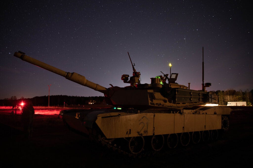 An M1A2 Abrams Tank from 2nd Battalion, 34th Armored Regiment, 1st Armored Brigade Combat Team, 1st Infantry Division marks the center lane during a night fire gunnery exercise at Konotop Range, Drawsko Pomorskie, Poland, Jan. 28, 2022. Soldiers perform night fire exercises to practice engagements and reinforce their operating skills. (U.S. Army photo by Sgt. Eliezer Meléndez)