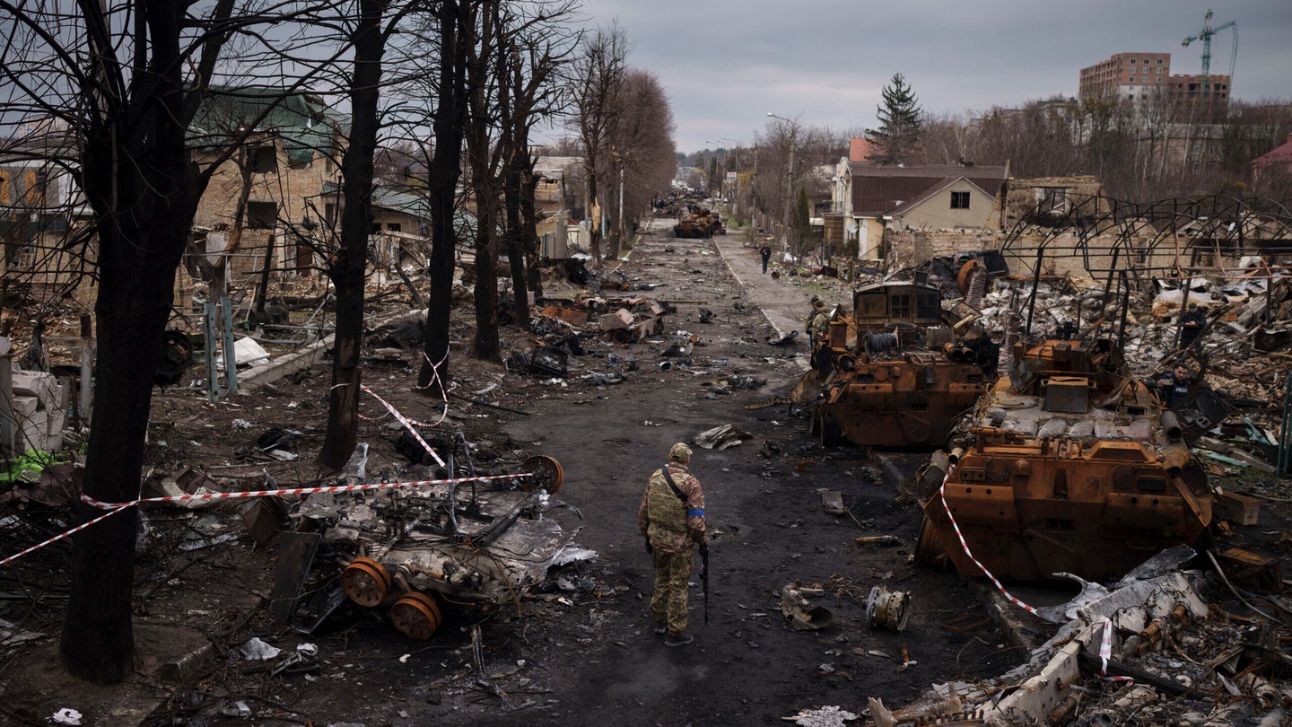 A Ukrainian serviceman walks amid destroyed Russian tanks in Bucha, on the outskirts of Kyiv, Ukraine, on April 6, 2022. (Felipe Dana/AP)