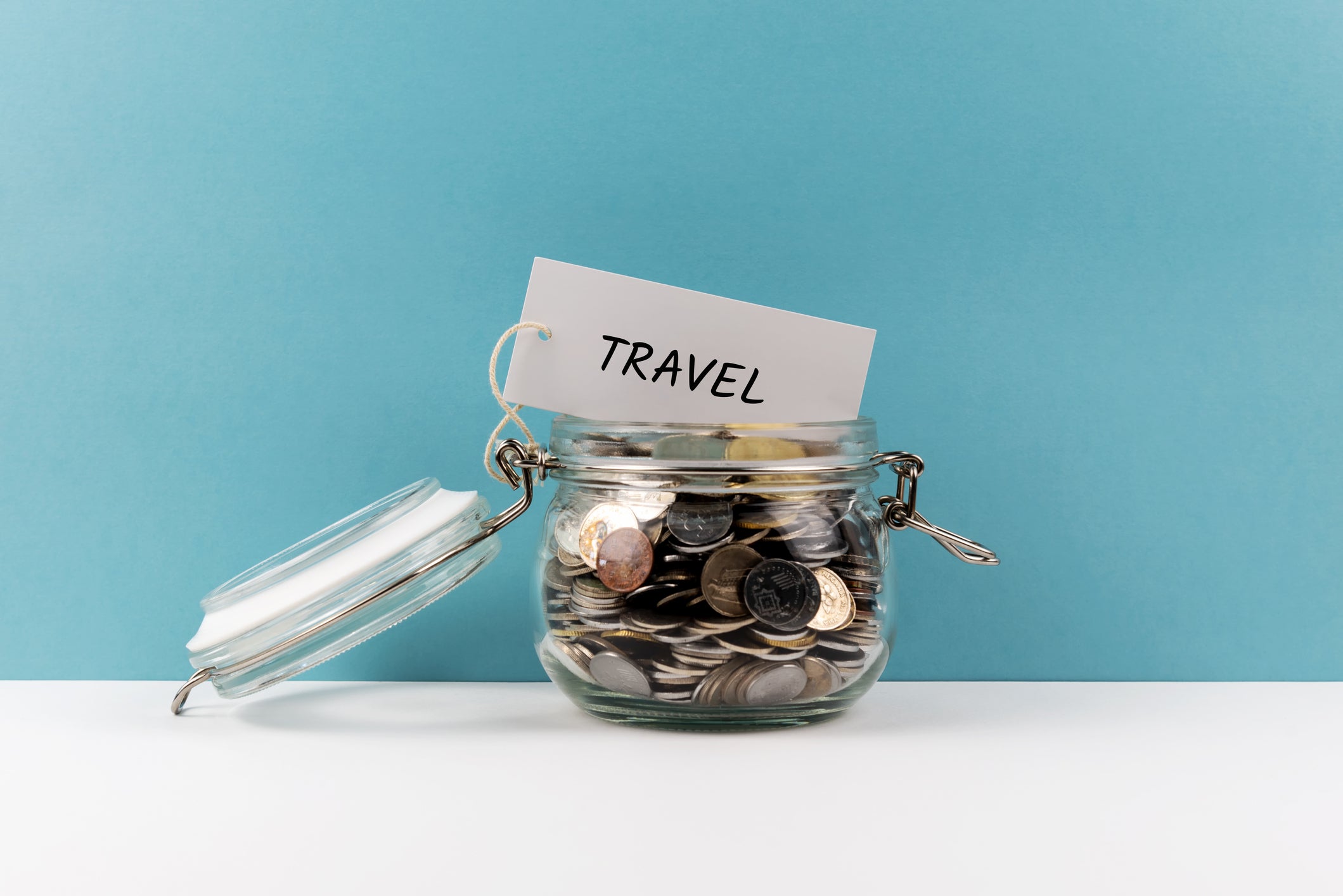 Travel Coin Jar On Colored Background - Home Finance Concept