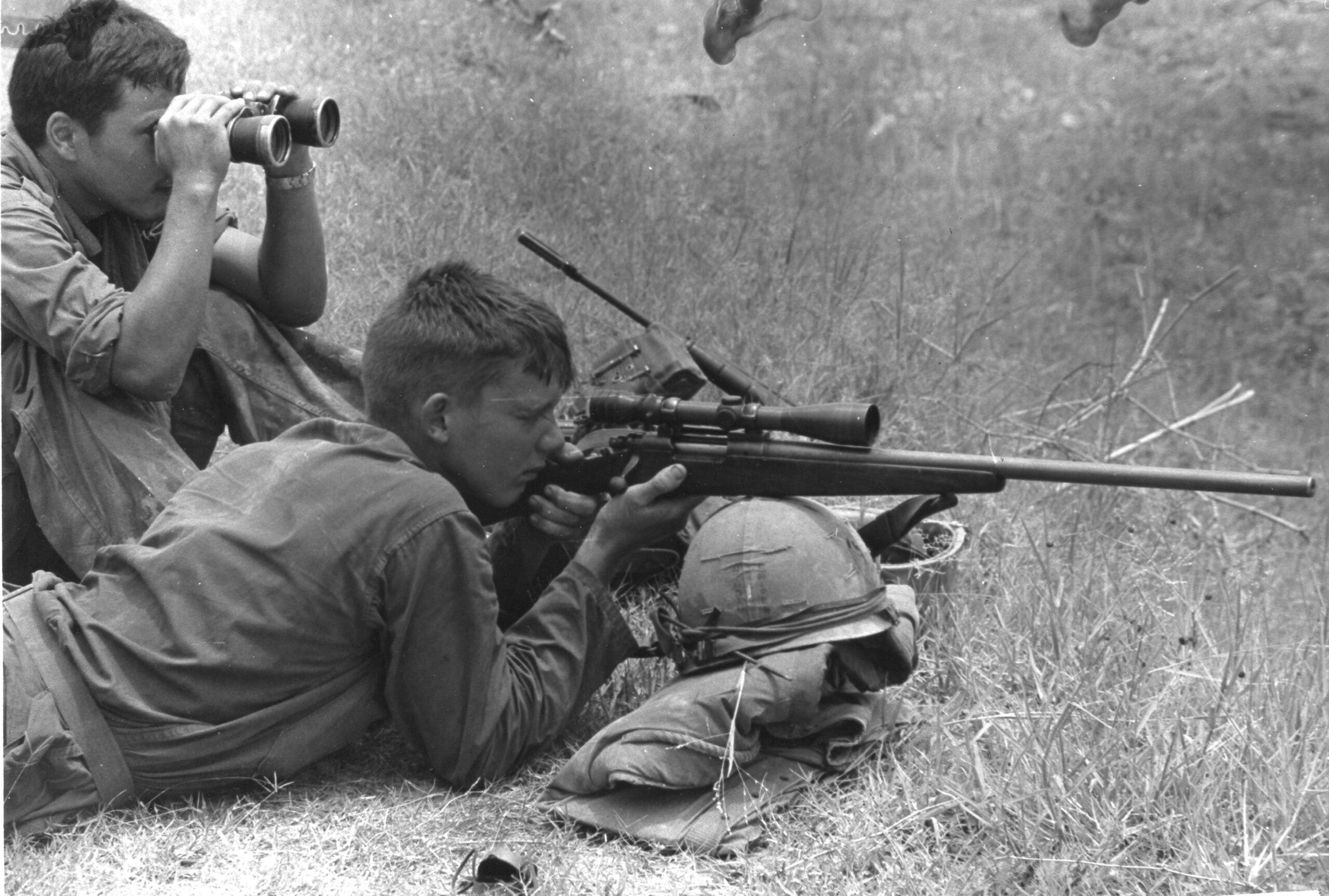 A 7th Marine Regt sniper zeroes in on a distant enemy with his Remington 700 sniper rifle, while his companion watches through binoculars, Da Nang, Vietnam, July 18, 1968. The two were working during Operation Mameluke Thrust. (Photo by PhotoQuest/Getty Images)