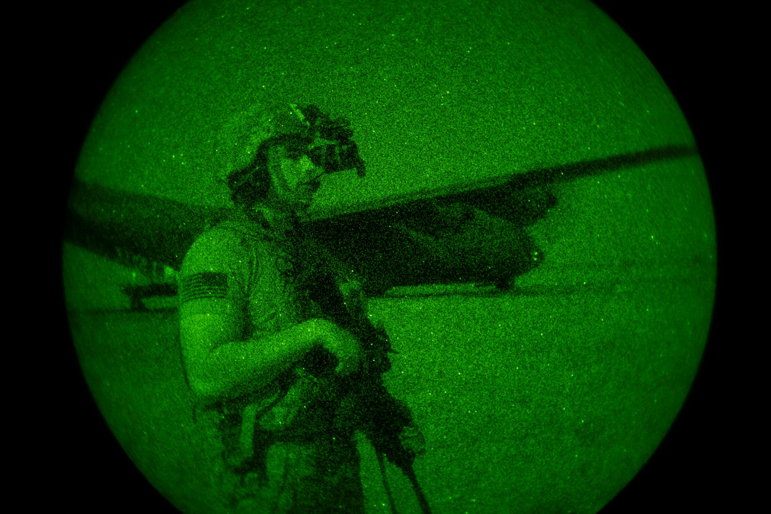 U.S. Army Spc. Dominic Deitrick, assigned to the 1-186th Infantry Battalion, Task Force Guardian, Combined Joint Task Force - Horn of Africa, seen through a night-vision device, provides security for a 75th Expeditionary Airlift Squadron (EAS) C-130J Super Hercules during unloading and loading operations Friday, June 12, 2020 at an unidentified location in Somalia. No country has been involved in Somalia's future as much as the United States but now the Trump administration is thinking of withdrawing the several hundred U.S. military troops from the nation at what some experts call the worst possible time. (Tech. Sgt. Christopher Ruano/Combined Joint Task Force - Horn of Africa via AP)