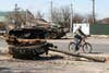 A man ride bike near Destroyed Russian military tank near Brovary, Kyiv area, Ukraine, 15 April 2022 (Photo by Maxym Marusenko/NurPhoto via Getty Images)