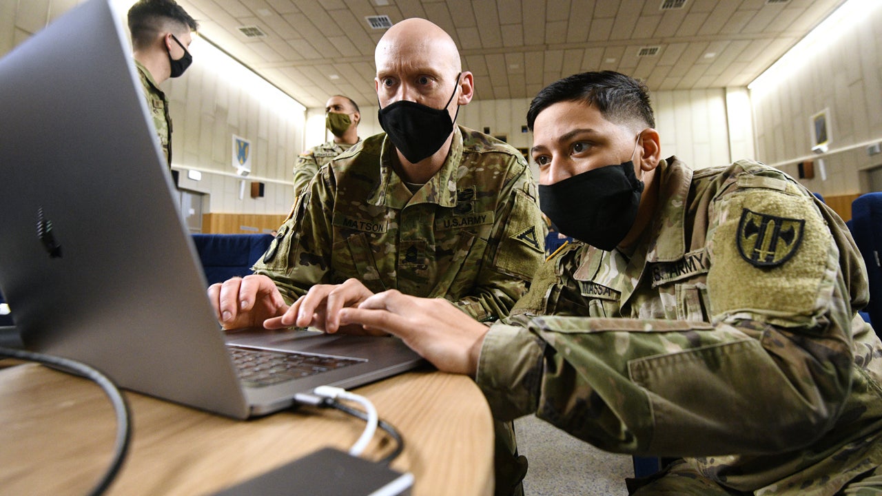 U.S. Army Master Sgt. Ryan Matson, left, with 7th Army Training Command Public Affairs Office and U.S. Army Pfc. Felicia Massa assigned to 709th Police Battalion review slides during the 7th ATC first annual Unit Public Affairs Representative Training at Rose Barracks, Vilseck, Germany, Dec. 3, 2020. (Gertrud Zach/U.S. Army)