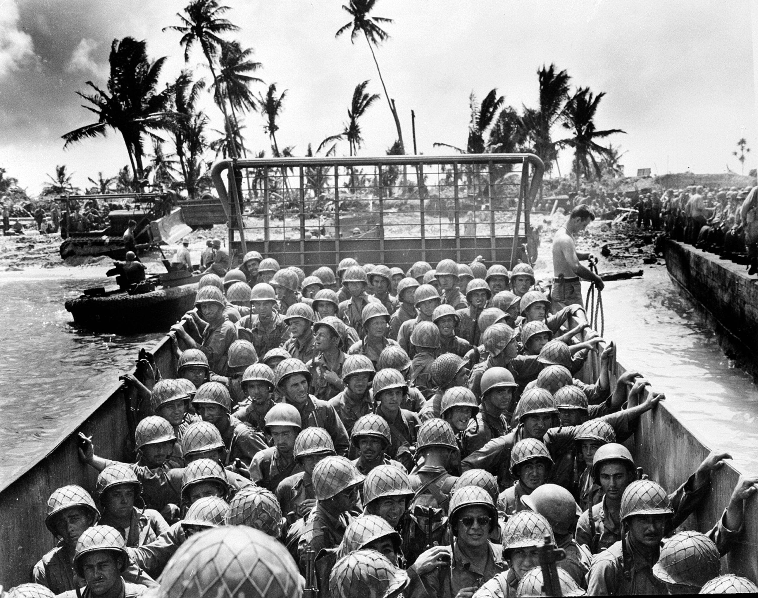 A landing craft packed with helmeted U.S. Marines, accompanied by U.S. Coast Guard, approaches the shore of an island in the Kwajalein Atoll during the American invasion of the Marshall Islands in the Pacific on March 2, 1944 during World War II.  (AP Photo/U.S. Coast Guard)