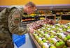 A U.S. Air Force Airman selects produce while grocery shopping at Ramstein Air Base, Germany, May 17 2022. Service members and their families living overseas in certain areas will experience a reduction in their overseas Cost of Living Allowance beginning June 1. The purpose of overseas COLA is to ensure that service members have the same purchasing power at overseas duty locations as in the U.S. Items such as groceries, car insurance, gasoline, and day care are taken into consideration when determining COLA rates.