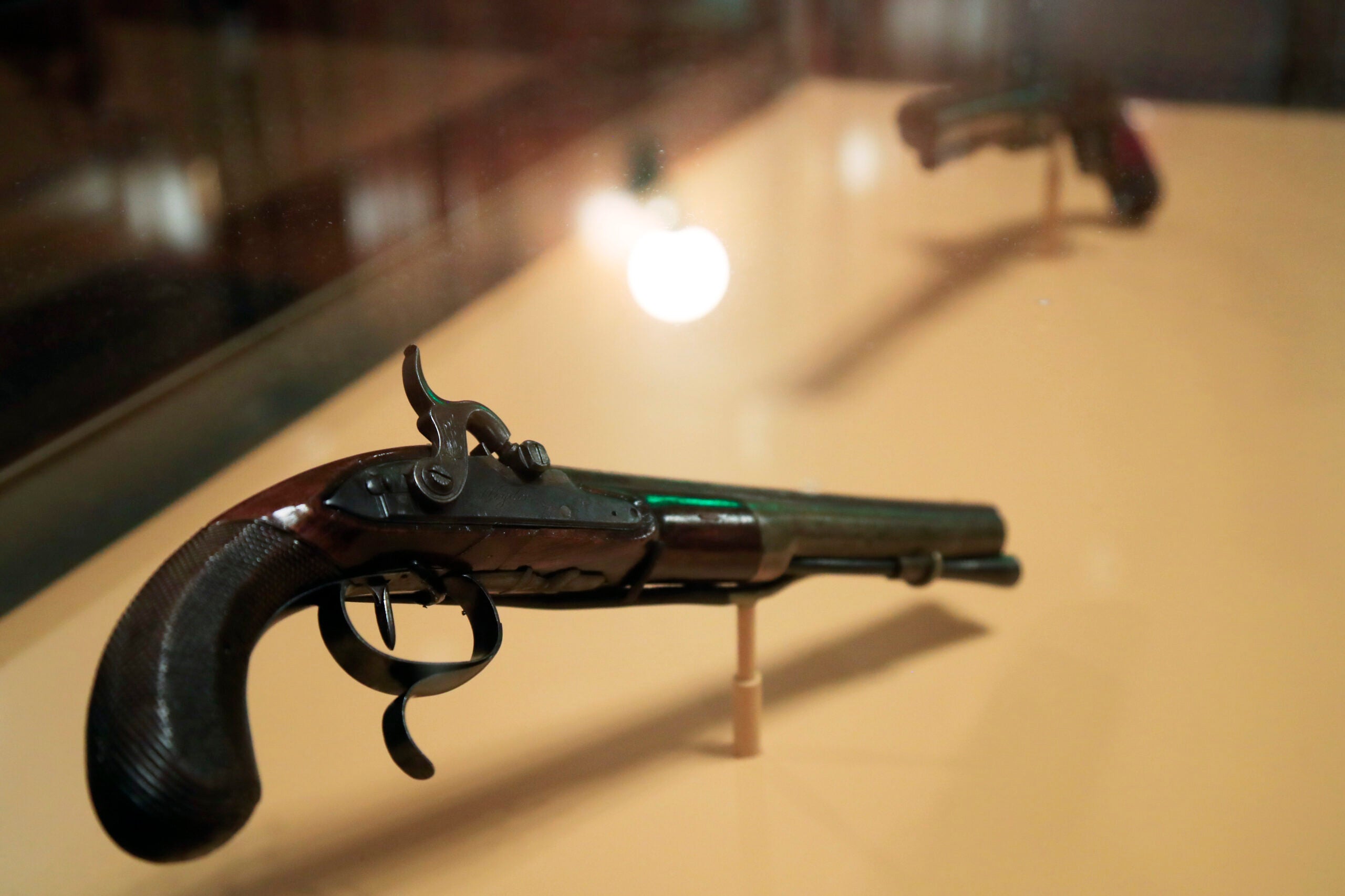 ADDS THAT THE PISTOL IN THE FOREGROUND WAS MODIFIED FROM A FLINTLOCK TO A CAP LOCK AT A LATER DATE - The original flintlock pistols made of walnut, brass and gold that were used in the July 11, 1804 duel with then-Vice President Aaron Burr, which resulted in the death of former secretary of treasury and a retired two-star Army General Alexander Hamilton, are displayed at Smithsonian National Postal Museum in Washington, Monday, June 11, 2018. The blockbuster show Hamilton is finally coming to the nation's capital and the city is preparing in ways that only Washington can. According to the Smithsonian Institution the pistol in the foreground was converted sometime during the Civil War era to a cap lock pistol from the original flintlock. (AP Photo/Manuel Balce Ceneta)