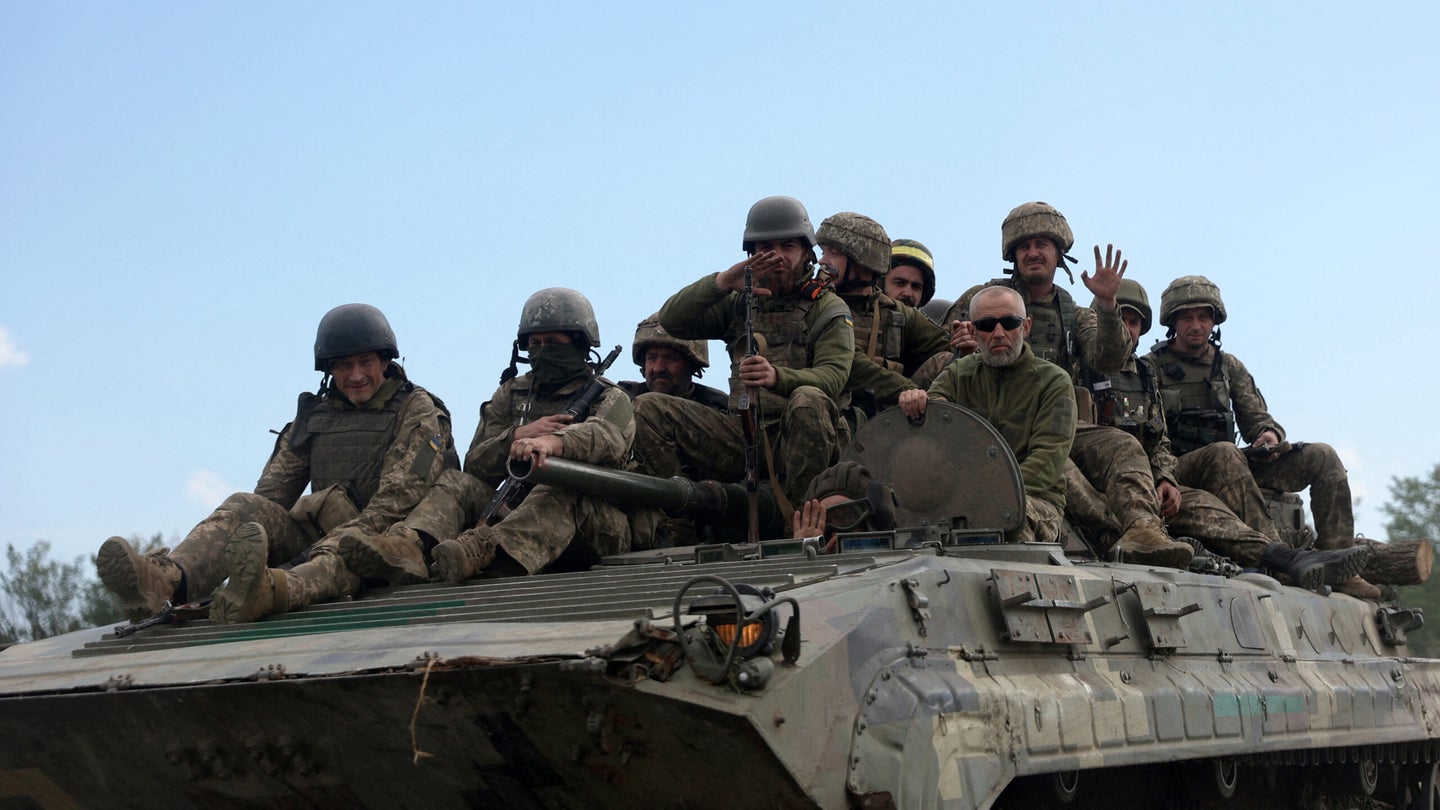 Ukrainian soldiers ride on an armored personnel carrier (APC) on a road of the eastern Luhansk region on June 23, 2022, amid Russia's military invasion launched on Ukraine. (Photo by Anatolii Stepanov / AFP) (Anatoli Stepanov/AFP via Getty Images)