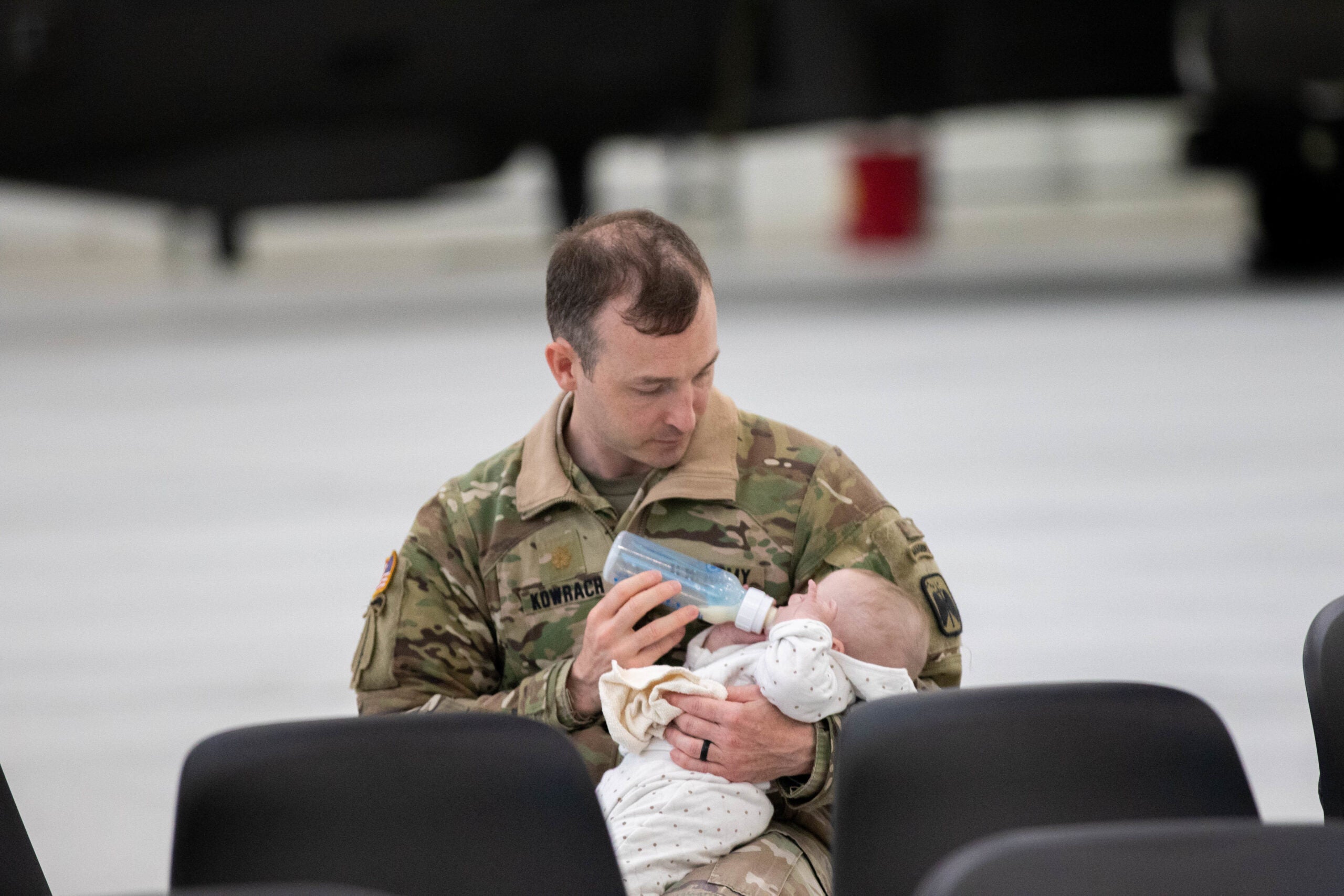 Maj. Jason Kowrach, the Brigade Operations Officer assigned to 16th Combat Aviation Brigade, cares for his baby while his spouse takes part in a spouse flight at Joint Base Lewis-McChord, Wash. on May 24 and 25, 2022. (U.S. Army photo by Capt. Kyle Abraham, 16th Combat Aviation Brigade)