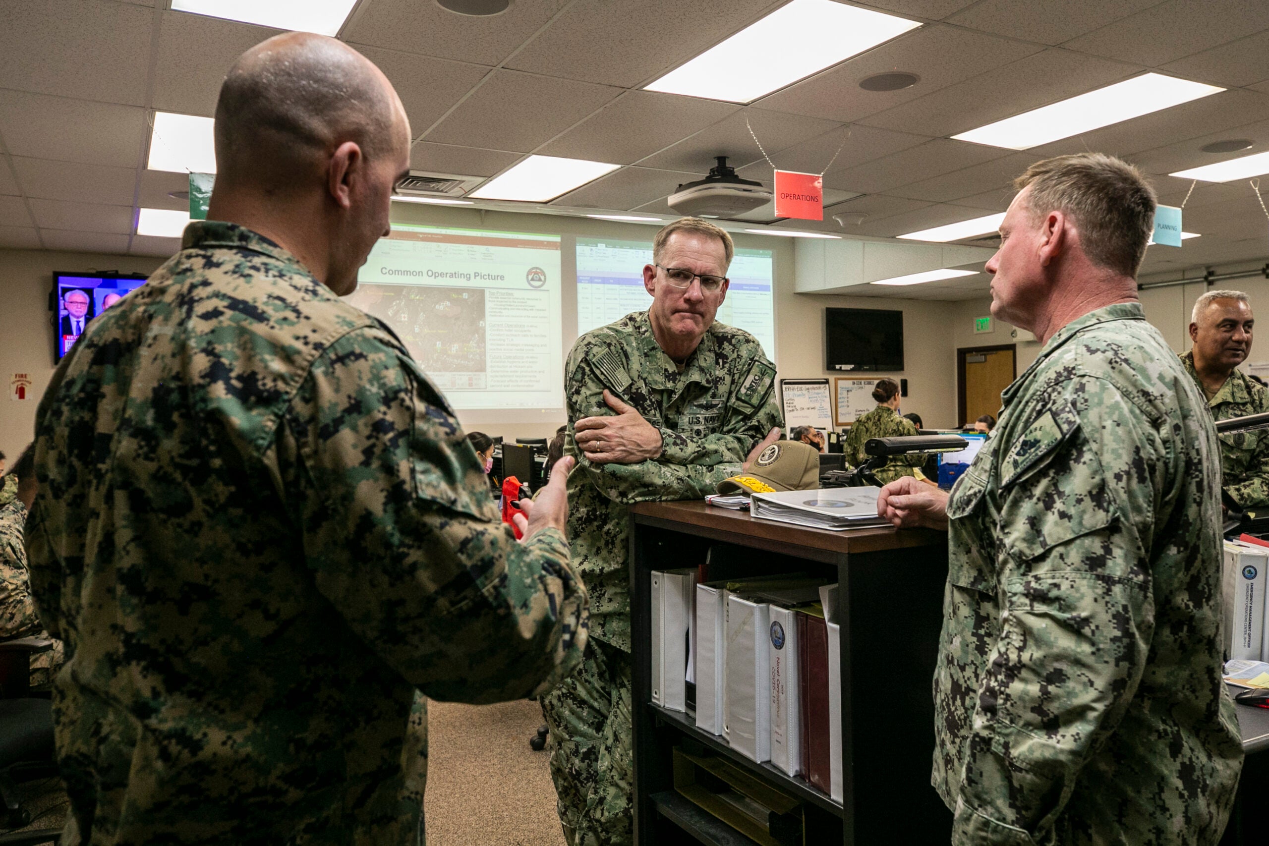 U.S. Navy Vice Admiral Yancy B. Lindsey, middle, commander of Navy Installations Command, speaks with U.S. Marine Corps Maj. Sean P. Day, left, operations officer for Combat Logistics Regiment 3, 3rd Marine Logistics Group (MLG), and Capt. Erik A. Spitzer, middle, commander of Joint Base Pearl Harbor-Hickam, during an Emergency Operations Center meeting on Joint Base Pearl Harbor-Hickam, Oahu, Hawaii, Dec. 11, 2021. U.S. Marines with 3rd MLG, as part of Task Force KULEANA, are providing support services such as drinking water, field expedient showers and laundry facilities to the residents of Joint Base Pearl Harbor-Hickam affected by the ongoing water issue. 3rd MLG, based out of Okinawa, Japan, is a forward deployed combat unit that serves as III Marine Expeditionary Force’s comprehensive logistics and combat service support backbone for operations throughout the Indo-Pacific area of responsibility. (U.S. Marine Corps photo by Sgt. Hailey D. Clay)