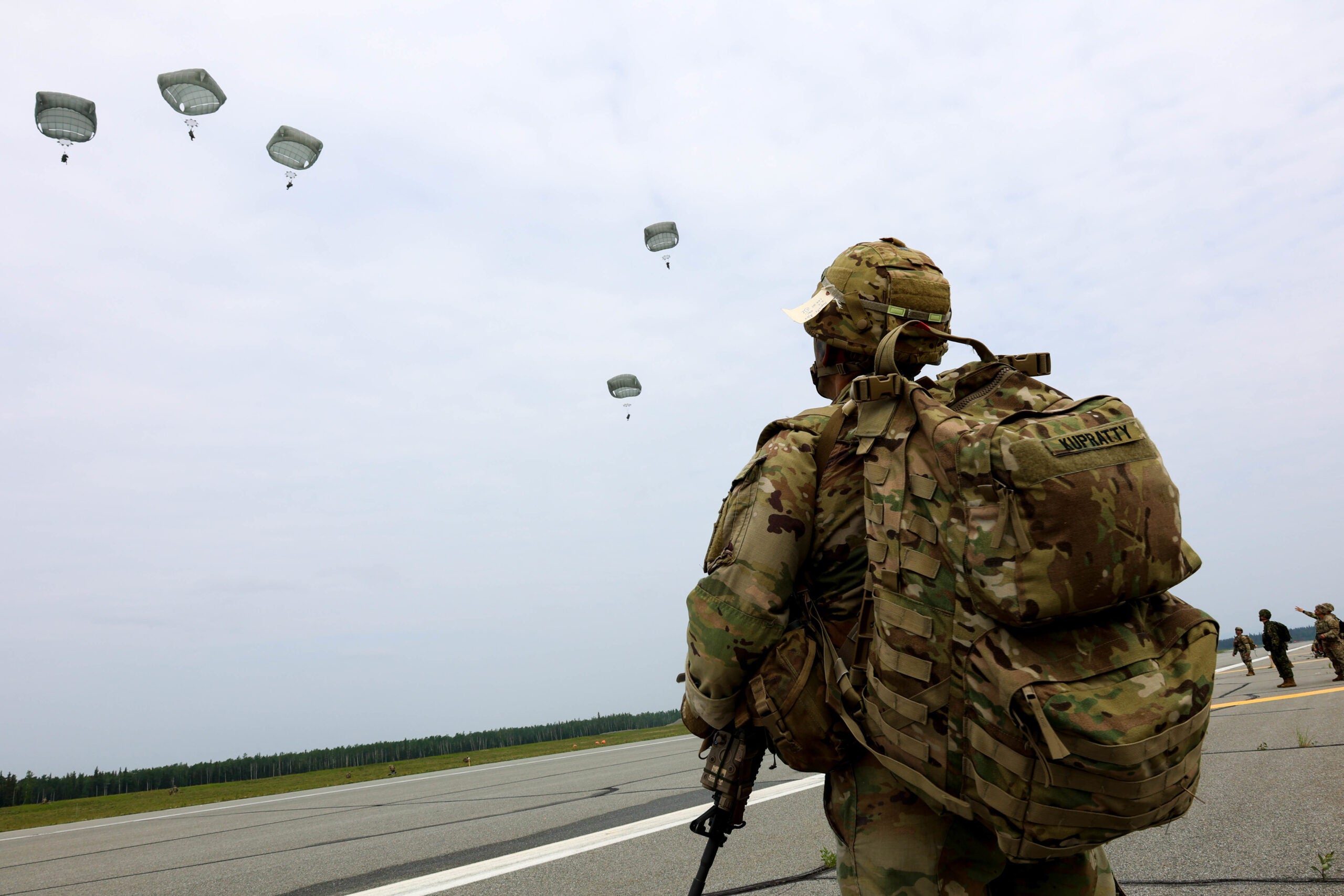 U.S. Army Command Sgt. Maj. Alex Kupratty, senior enlisted advisor for 2nd Infantry Brigade Combat Team (Airborne), 11th Airborne Division, observes Paratroopers assigned to 3rd Battalion, 509th Parachute Infantry Regiment, seize an airfield during RED FLAG-Alaska 22-2 over Allen Army Airfield, Fort Greely, Alaska, June 15, 2022. The exercise provides unique opportunities to integrate various forces into joint, coalition and multilateral training from simulated forward operating bases.