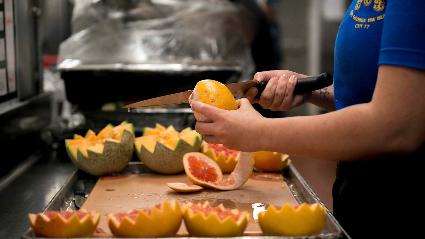 Culinary Specialist Seaman Mary Hill, from Hillsboro, Illinois, carves fruit aboard the aircraft carrier USS George H.W. Bush (CVN 77). (U.S. Navy photo by Mass Communication Specialist 3rd Class Omar A. Diaz)