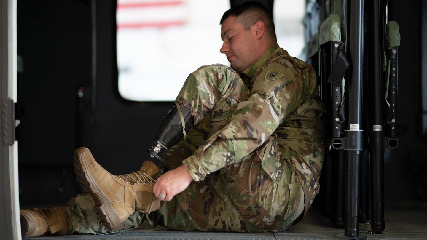 Sgt. Alex Woodsmall, a recruiter for the Indiana National Guard, demonstrates how he puts his combat boots on while in uniform at the Shelbyville National Guard Armory, Oct. 6, 2020. (Sgt. Joshua Syberg/U.S. National Guard)