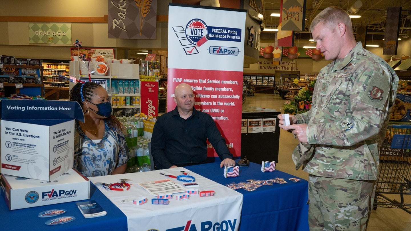 Master Sgt. Blayne Ralston, right, 66th Group Staff Agency first sergeant, speaks with Tracey Hall, installation voting program manager, and Michael Glover, Airman and Family Readiness Center causality assistance representative, during an Armed Forces Voting Week event at Hanscom Air Force Base, Massachusetts. (Todd Maki/U.S. Air Force)