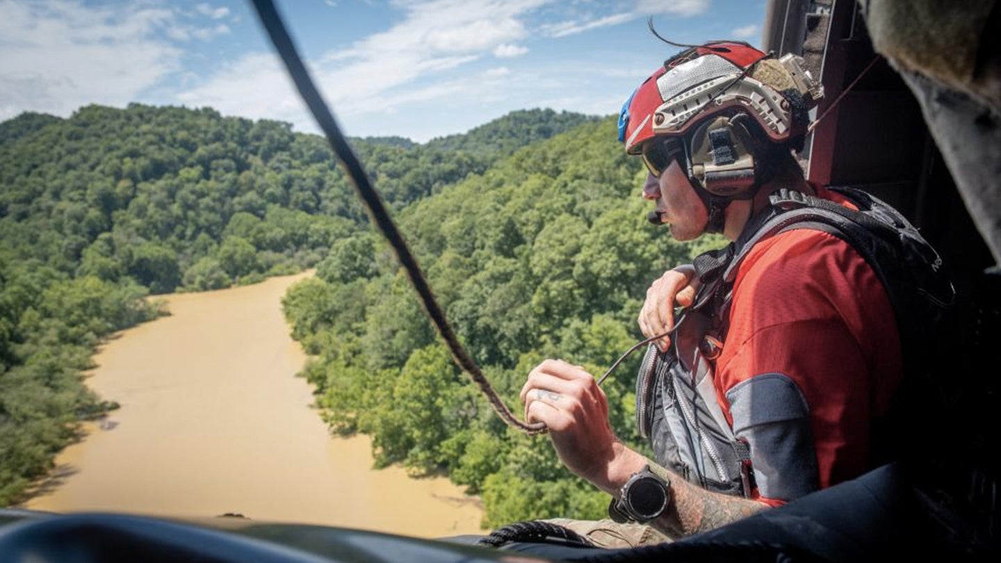 An Airman from the Kentucky Air National Guard’s 123rd Special Tactics Squadron search for flood victims from a helicopter in Eastern Kentucky on July 30, 2022. (Staff Sgt. Clayton Wear / U.S. Air National Guard)