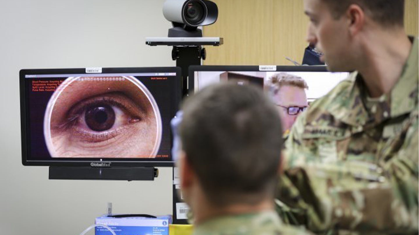 In a demonstration of the Telehealth process at Fort Campbell's Blanchfield Army Community Hospital, clinical staff nurse Lt. Maxx P. Mamula examines mock patient Master Sgt. Jason H. Alexander using a digital external ocular camera. The image is immediately available to Lt. Col. Kevin A. Horde, a provider at Fort Gordon's Eisenhower Medical Center, offering remote consultation. (Gigail Cureton)