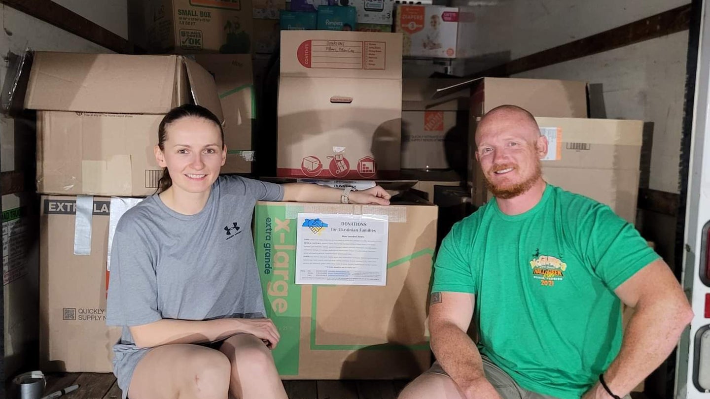 U.S. Staff Sgt. Adrianna Choluj, 1st Special Operations Wing noncommissioned officer in charge of protocol, left, and Tech. Sgt. Ian Gateley, 325th Civil Engineer Squadron explosive ordnance technician, right, pose for a photo with goods collected for a donation drive for those in need after Russia’s invasion of Ukraine. (Courtesy Photo/325th Fighter Wing Public Affairs)