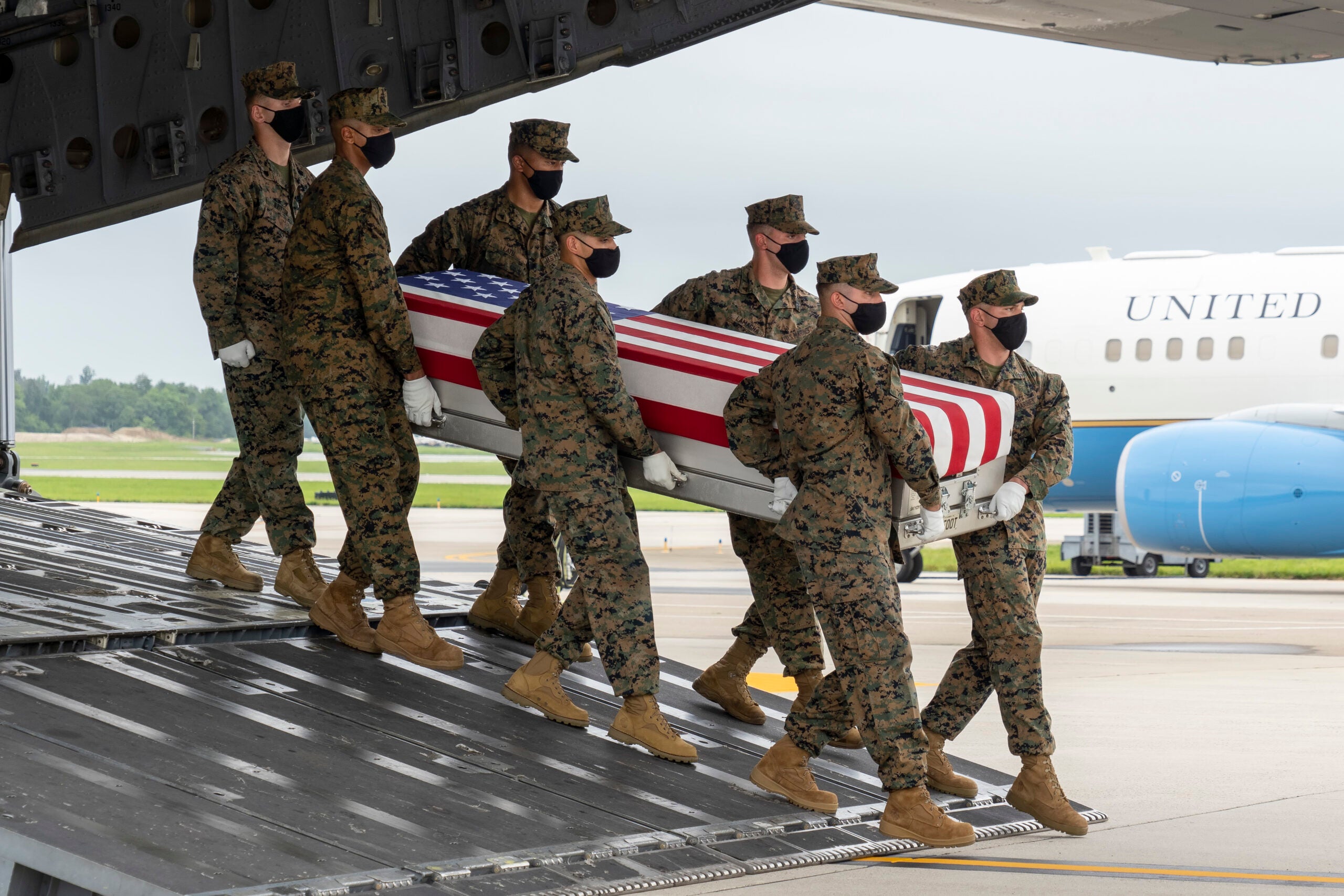 DOVER, DELAWARE - AUGUST 29: In this handout photo provided by the U.S. Air Force, a U.S. Marine Corps carry team transfers the remains of Marine Corps Sgt. Nicole L. Gee of Sacramento, California, Aug. 29, 2021 at Dover Air Force Base, Delaware. Gee was assigned to Combat Logistics Battalion 24, 24th Marine Expeditionary Group, II Marine Expeditionary Force, Camp Lejeune, North Carolina.  (Photo by Jason Minto/U.S. Air Force via Getty Images)