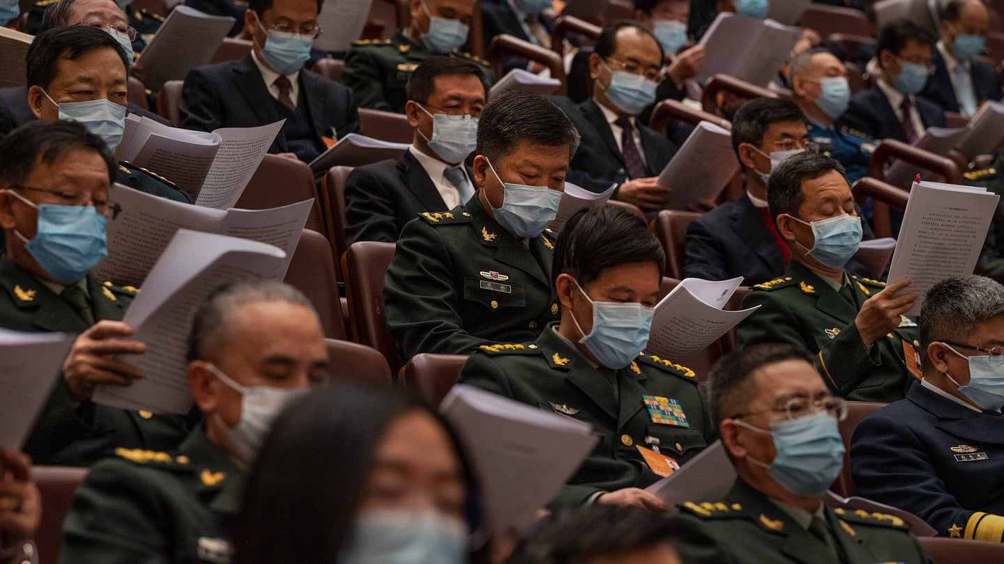 Attendees, many from the Chinese military, listen in the gallery at the opening session of the National Peoples Congress at the Great Hall of the People on March 5, 2022 in Beijing, China. (Kevin Frayer/Getty Images)