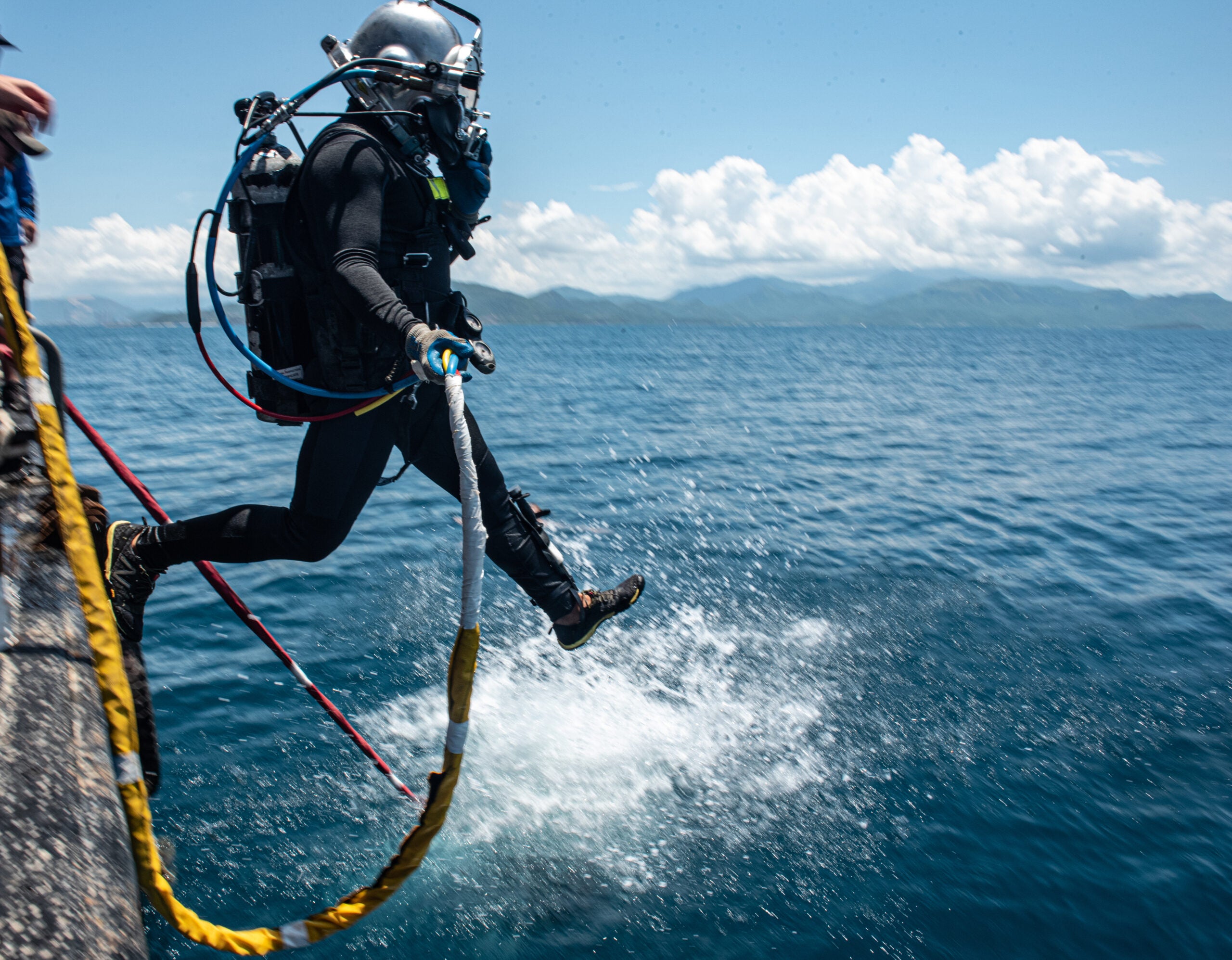 U.S. Army Sgt. Marc Falcon, 7th Engineer Dive Detachment salvage diver, enters the water off of a barge during a Defense POW/MIA Accounting Agency (DPAA) recovery mission in Nha Trang province, Vietnam, May 15, 2021. Falcon is one of the many divers that DPAA entrusts to go below the surface of the ocean and search for the remains of service members from past conflicts. DPAA’s mission is to achieve the fullest possible accounting for missing and unaccounted U.S. personnel to their families and the nation.  (U.S. Army photo by Sgt. Mitchell Ryan)