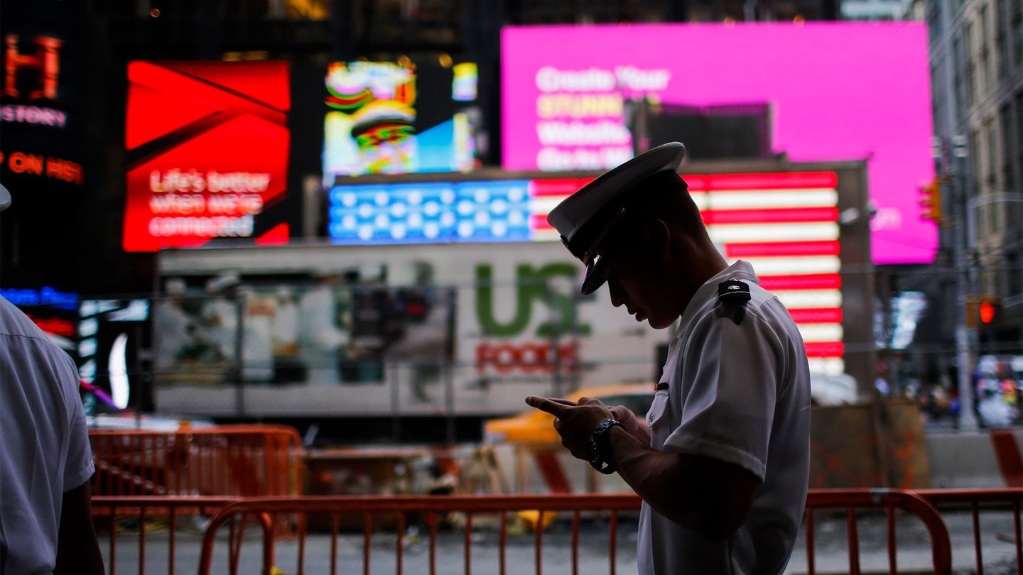 A Sailor checks his mobile phone as he walks around Times Square during Fleet Week on May 25, 2016 in New York City. (Photo by Eduardo Munoz Alvarez/Getty Images)