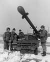 30th December 1960:  A U.S. Army soldier operates a Davy Crockett mounted on a jeep as three fellow soldiers stand by and watch on a snow-covered road during the Vietnam War. The Davy Crockett is the U.S. Army hand or jeep portable weapons system capable of firing atomic or conventional warheads in support of the Army's front line pentomic battle groups. The nuclear warhead was developed by the Atomic Energy Commission.  (Photo by Hulton Archive/Getty Images)