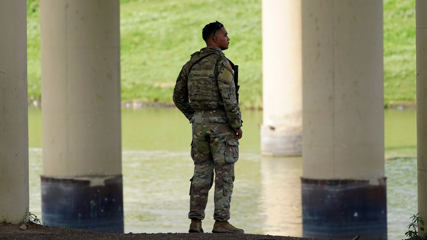 A member of the Texas National Guard looks across the Rio Grande to Mexico from the U.S. at Eagle Pass, Texas, Friday, Aug. 26, 2022. (Eric Gay/Associated Press)