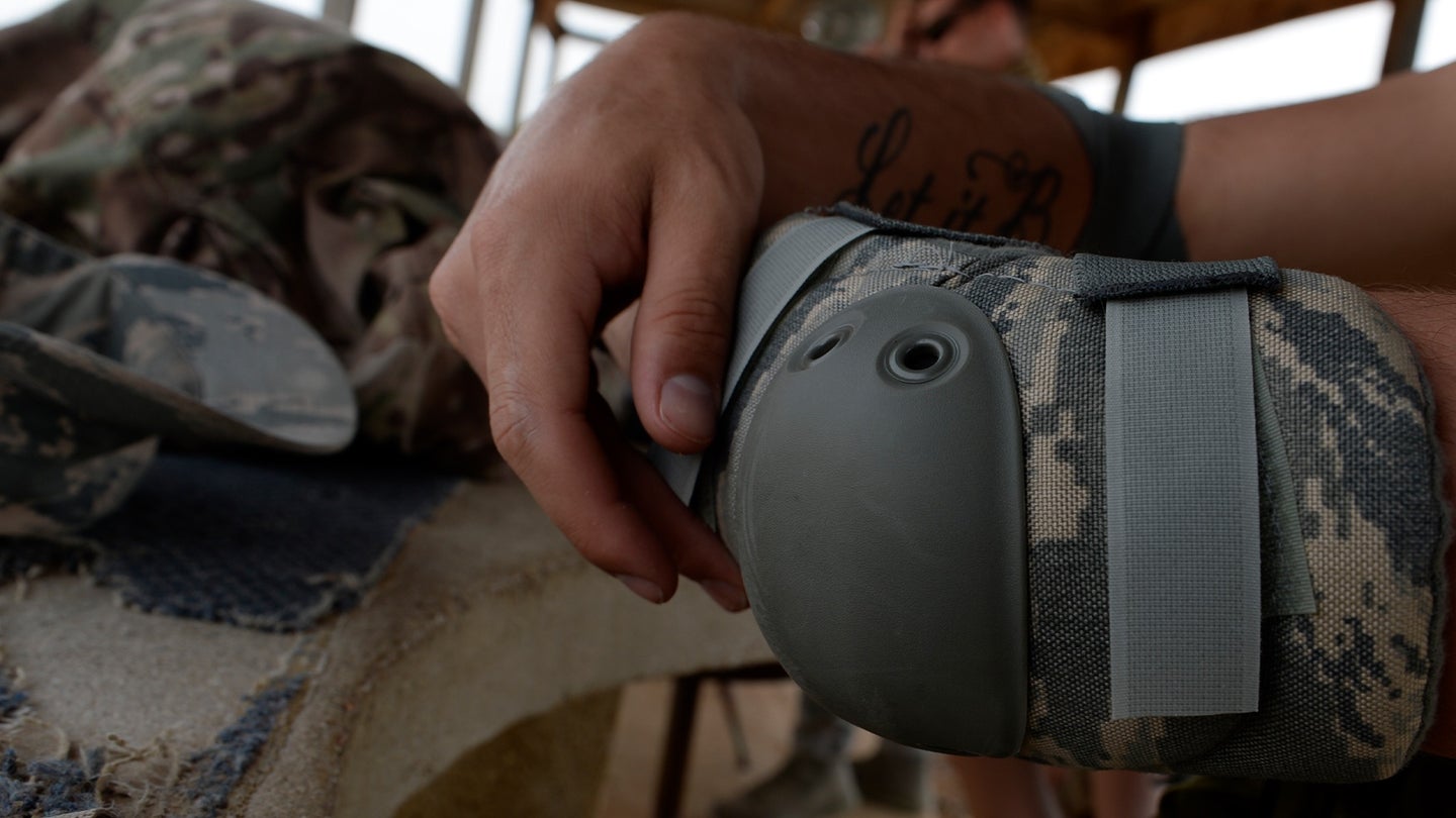 Senior Airman Thomas Smith, 3rd Combat Camera Squadron combat broadcaster, straps on elbow pads while participating in Advanced Weapons and Tactics Training at a shooting range in Atascosa, Texas, May 7, 2014. (U.S. Air Force photo/Airman 1st Class Justin Wright)