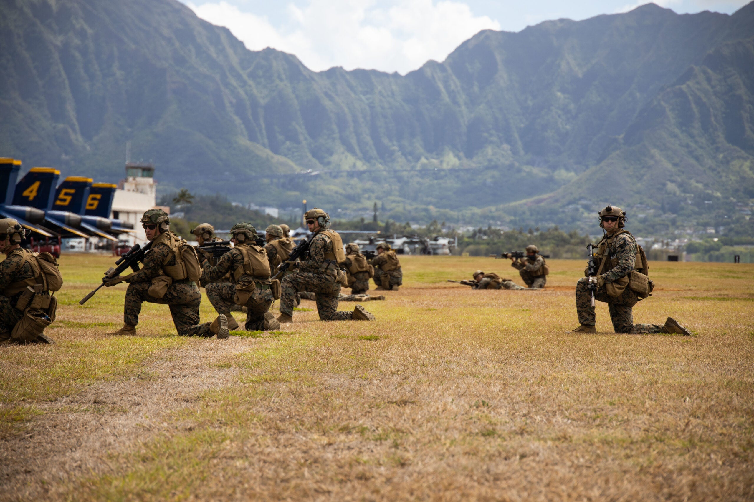 U.S. Marines with 3d Littoral Combat Team, 3rd Marine Littoral Regiment, take a knee and survey the surrounding area during a Joint Air-Ground Task Force Demonstration as part of the 2022 Kaneohe Bay Air Show, Marine Corps Air Station Kaneohe Bay, Marine Corps Base Hawaii, Aug. 13, 2022. The air show provided an opportunity to showcase the aircraft, equipment and capabilities of the armed forces to the local community. The Kaneohe Bay Air Show, which contained aerial performances, static displays, demonstrations and vendors, was designed to celebrate MCBH’s longstanding relationship with the local community. (U.S. Marine Corps photo by Cpl. Brandon Aultman)