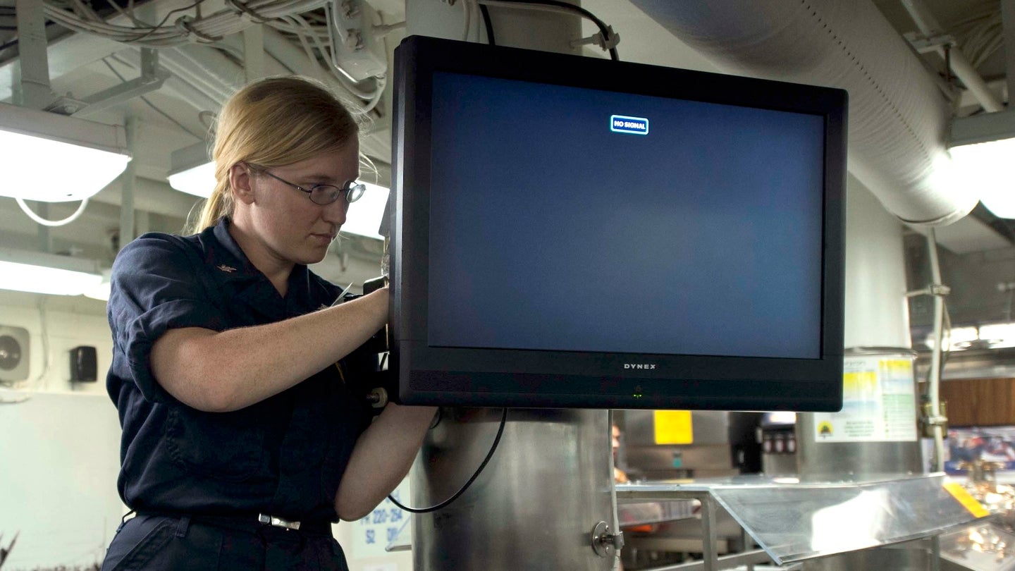 Interior Communications Electrician 3rd Class Marissa A. Burton connects a television on the mess decks of the Arleigh Burke-class guided-missile destroyer USS Dewey (DDG 105) on Sept. 15, 2014.