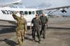 U.S. Air Force Maj. Kevin Skelton, a 6th Special Operations Squadron AC-208 evaluator pilot and combat aviation advisor, conducts a walk-around of an AC-208 with Latvian Air Force Majs. Girts Volframs, aviation squadron commander, and Linards Gurtins, AN-2 flight commander. (2nd Lt. Jason Barkey/U.S. Air Force)