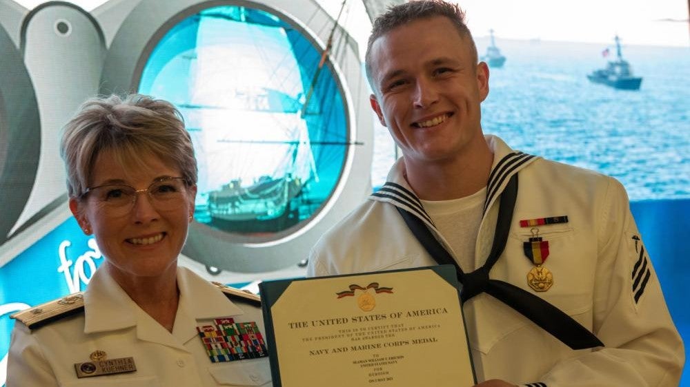 Rear Adm. Cynthia Kuehner, commander of Naval Medical Forces Support Command and Hospital Corpsman William T. Ericson, after she presented him with the Navy and Marine Corps Medal. (U.S. Navy)