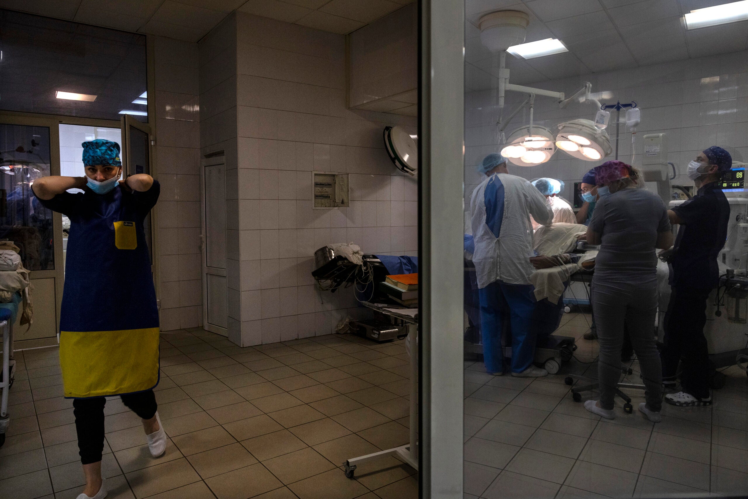 KYIV REGION, UKRAINE - OCTOBER 27:A nurse walks by as an operation takes place to extract a bullet from a solders back on October 27, 2022 at a military hospital in the Kyiv region, Ukraine. The military hospital treats all of the military war wounded for free.
(Photo by Paula Bronstein / Getty Images)