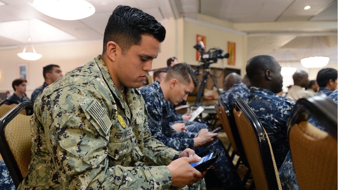 Master-at-Arms 2nd Class John Hernandez, assigned to Helicopter Maritime Strike Squadron (HSM) 79, uses his smart phone to respond during a live-polling session at the second annual Career Development Symposium at Anchors Conference Center near Naval Base San Diego. (Chief Mass Communication Specialist Dustin Kelling/U.S. Navy)