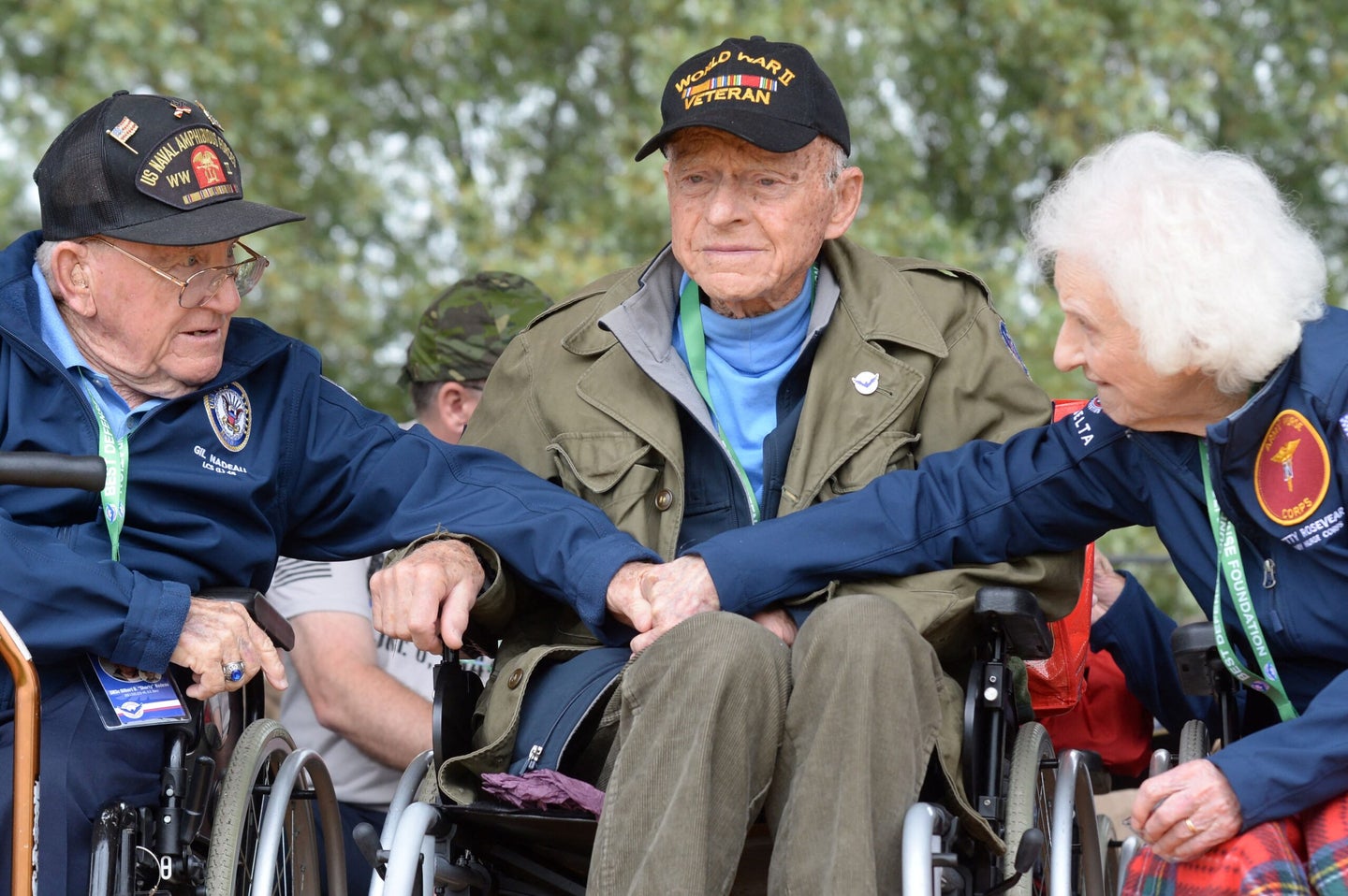 US World War II veterans: 2Lt Betty L. Huffman-Rosevear (Army Nurse Corps) (R) shakes hands with US Navy veteran SM3c Gilbert D. Nadeau (aka "Shorty") next to US veteran Andre Chappaz (C) from the 1885th Aviation Engineer Battalion, during the celebrations for the 78th D-Day anniversary, marking the WWII Normandy landings of June 6, 1944, in Sainte-Mere-Eglise on June 5, 2022. (Photo by JEAN-FRANCOIS MONIER / AFP) (Photo by JEAN-FRANCOIS MONIER/AFP via Getty Images)